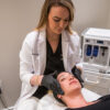 Aesthetic professional performing a C2 Glow Infusion TX on a female client at C2 Aesthetics