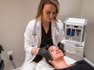 Aesthetic professional performing a C2 Glow Infusion TX on a female client at C2 Aesthetics