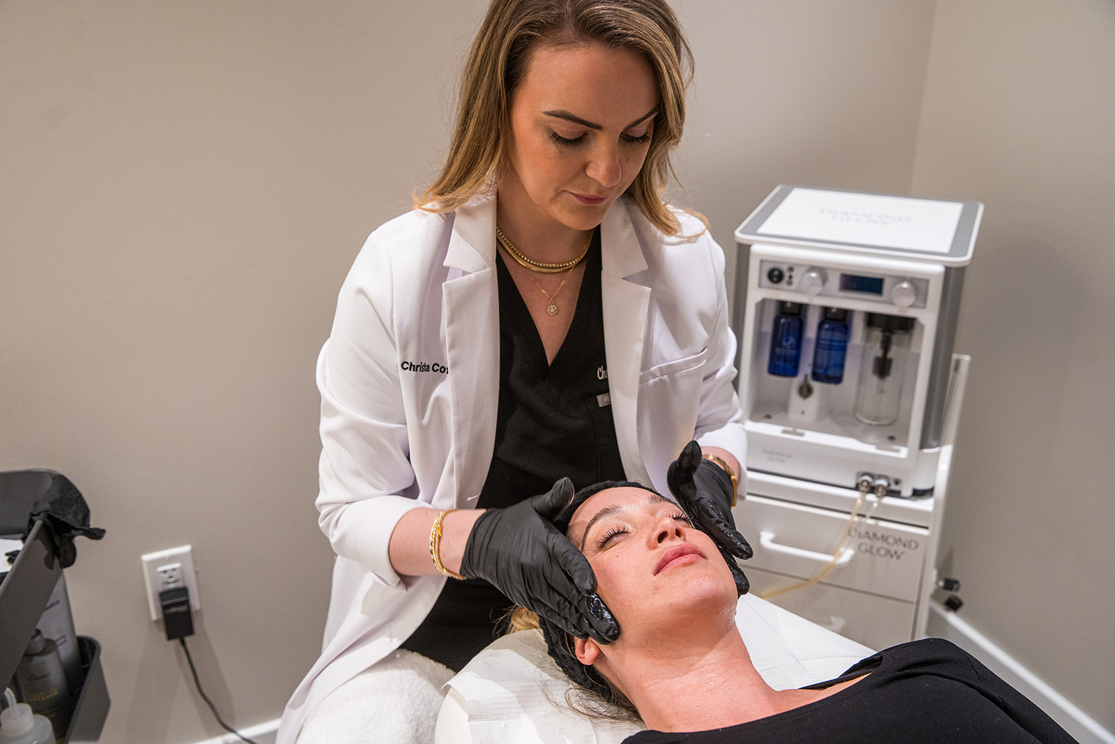 Aesthetic professional performing a C2 Glow Infusion TX on a female client at C2 Aesthetics