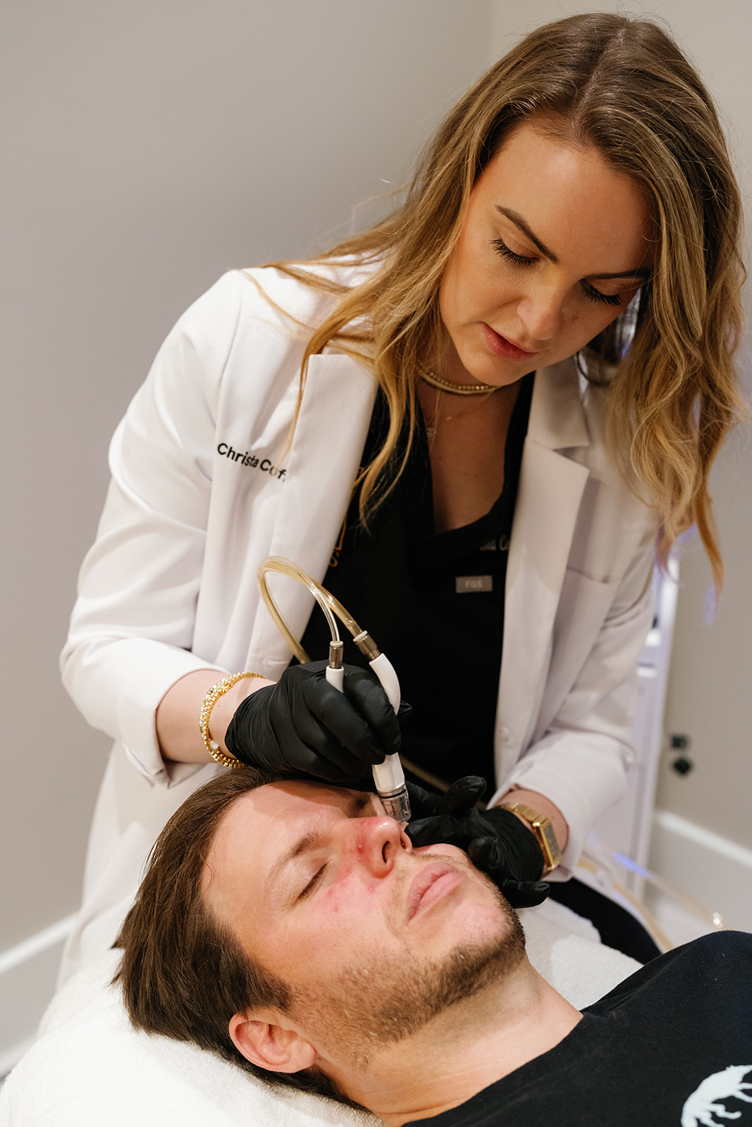 Aesthetic professional performing a C2 Glow Infusion TX on a male client at C2 Aesthetics